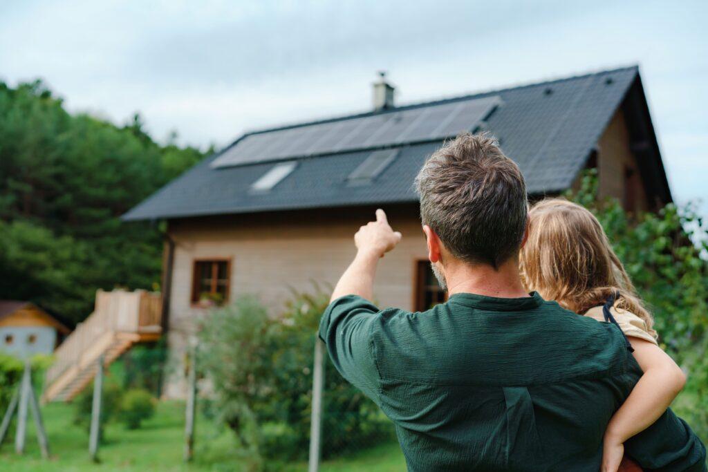 Ein Vater mit Kind zeigt auf ein Haus